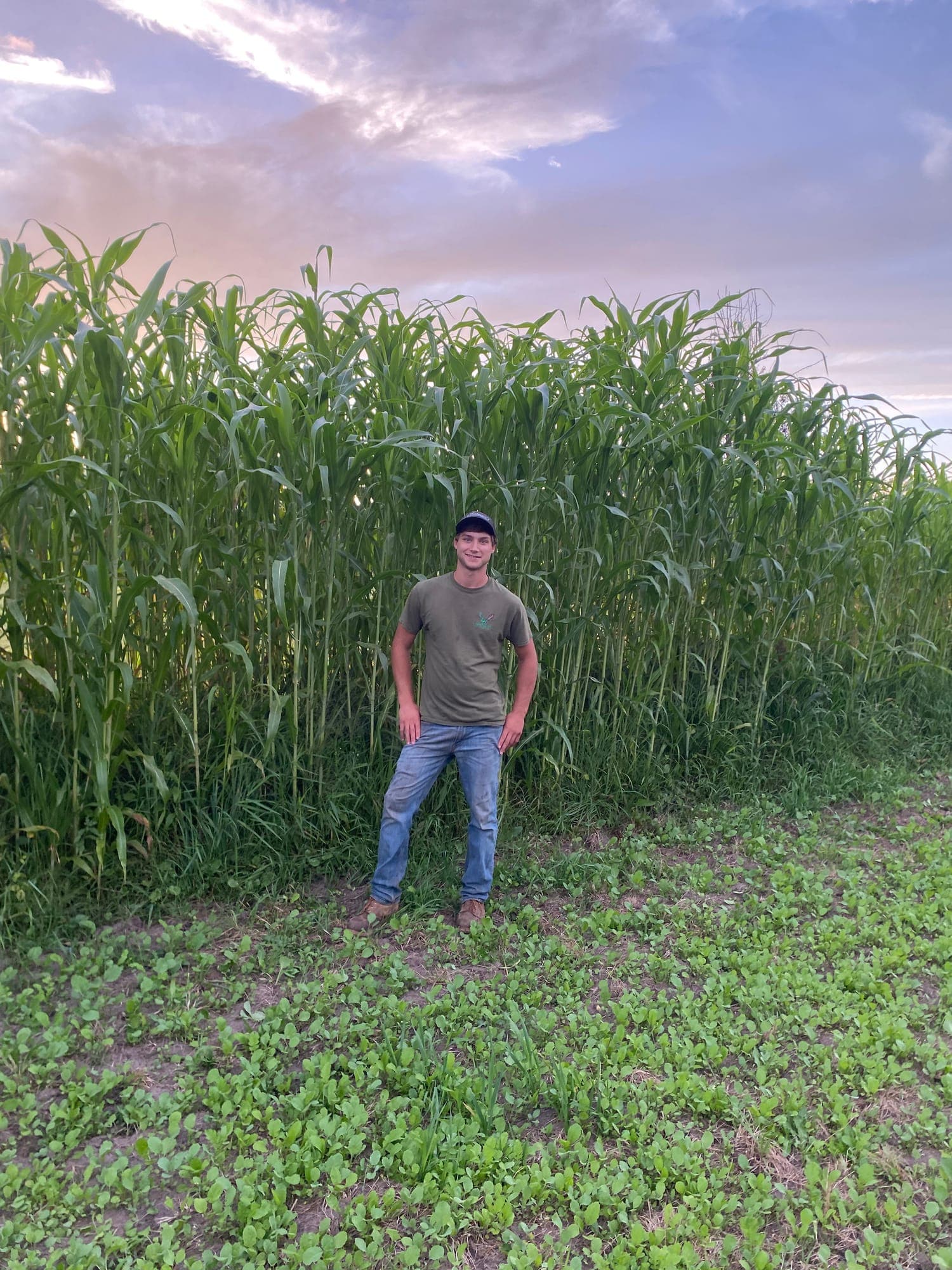 Standing in front of a tall sorghum screen planting